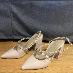 Beige klackar - Beige klackar med spetsig tå och nitar. Skorna är från märket raid. Klackhöjd 9,5 cm. Använda ett fåtal gånger🩷 