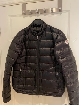 Moncler Acourus Svart - Hej, säljer nu min Moncler jacka då den inte används.  Skickar ej då jag inte orkar med strul!  Size 4 (passar mig, 190cm M)  Köpt innan vintern.  Vänster dragkedja för fickan fastnar ibland. Cond 8,5/10  Ge gärna bud om priset inte passar dig :)