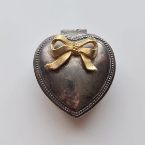 Vintage Smyckeskrin Hjärta - Supersött hjärtformat smyckeskrin med en rosett på locket. Invändigt är asken klädd i rött tyg. Finns i Täby C. Kan fraktas.