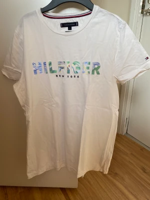 Tommy hilfiger T-shirt - Vit somrig Hilfiger T-shirt som är för lite för mig. Cond 8/10