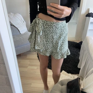 Kjol - Ljusgrön kjol med knytning framtill. Modellen är 176 och bär storlek S. Normal passform. Köpt från Veromoda. 