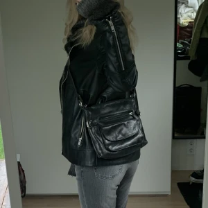 Axelremsväska från Vezzano - Svart axelremsväska från Vezzano. Reglerbart band. Jättefint skick och fin väska!! Rymlig