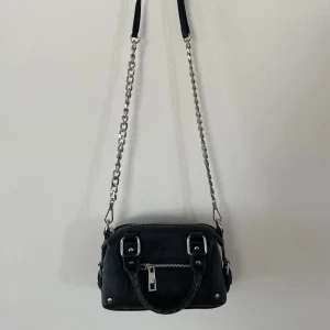 Slutsåld Núnoo- mini Bobby väska svart - En Núnoo Mini Bobby, svart liten axelremsväska i läder med kedja. Knappt använd fått i present. Mycket gott skick. Vid snabb affär kan priset diskuteras.