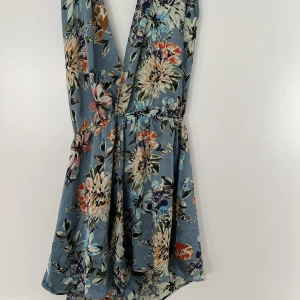 Shortsdress - En shortsdress från LOAVIES. Svårt att få med på bild men överkroppen består av 2 långa breda band som man antingen knyter bakom nacken  eller snurrar runt midjan. Öppen i rygg, går att styla som man vill. Storlek S men passar även M och liten L 