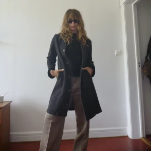 Jeanskappa/ klänning - En jeansklänning eller jeanskappa med tryckknappar frantill och krage. Gråsvart. Storlek M/L. Jag är 175cm och bär vanligtvis M. 