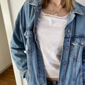 Oversized jeansjacka - Denna jeansjacka är av jeansmaterial i bra kvalité. Den är köpt secondhand och använd ett par gånger. Den har några medvetna rivningar men det är meningen. 