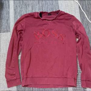 Vinröd/ röd tröja från Hugo boss, ett tryck över brösten. Köpt för några månader sen så är inte använd speciellt mycket så den är så gott som ny.