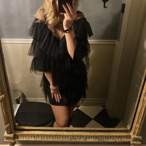 Svart volang tyll klänning - Säljer min älskade klänning som passar perfekt till nyår!! Köpte den på Ellos för två år sedan men finns inte kvar på hemsidan. 300+ frakt eller om flera är intresserade startar jag en budgivning!❤️‍🔥❤️‍🔥 står ingen storlek i men passar mig som vanligtvis är M.