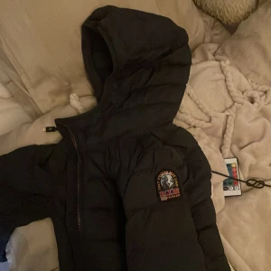 Parajumper vindjacka - Min parajumper vindjacka lång i dam modell. Storleken är s. Den är kanppt använd, har legat i en flyttlåda, under en viss tid. 