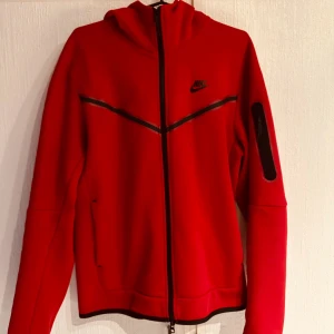 Nike tech fleece röd  - Säljer min röda Nike tech fleece på grund av att jag vill ha en annan färg. Storlek M, använt fåtal gånger. Nypris 1350 kr. 