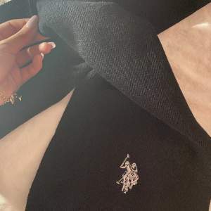 En svart enkel halsduk med U.s polo Assn märket på. Oanvänd, nyskick