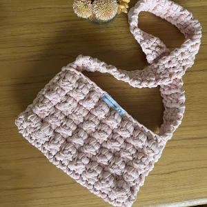 Crossbodybag - Egengjord virkad väska som är tänkt att bäras över kroppen🩷 Mått: 26x56cm Fler virkade produkter finns på @virkadavenkompis på instagram❤️‍🔥