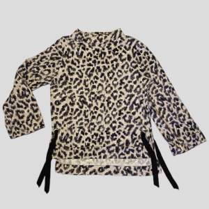 Leopardmönstrad tröja med snörning i sidorna. Hög hals (båthals) och långa ärmar. Står varken märke eller strl men skulle säga att det är en small eller medium. 