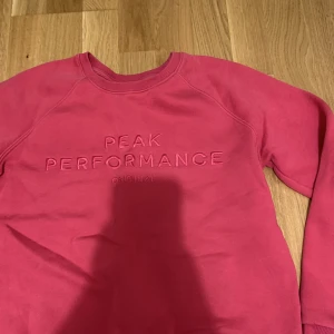 Sweatshirt  - Rosa sweatshirt från peak performance i mycket fint skick bortsett från en liten defekt i baksidan av högerarmen (se bild 2)💕