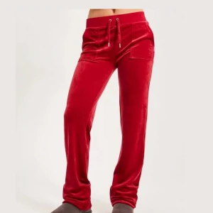 Juicy couture byxor - Säljer mina röda juicy byxor för att jag inte använder de längre. Inga tecken på användning förutom att de två metall sakerna som ska sitta på snöret är borta som syns tydligare på bild tre. Har varit uppsydda men inget som syns men kan vara bra att veta💕