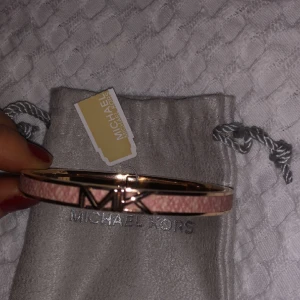 Michael kors armband - Ett rose Michael kors armband i roseguld, rosa helt oanvänd. Inköpt för 1.100kr kommer med en box och en påse.