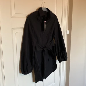 Skjortklänning från Prettylittlething  - Säljer denna snygga skjortklänning från Prettylittlething. Storlek 32, passar även lite större med. Helt ny och lappen sitter kvar. 
