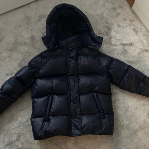 Polo jacka - Säljer min super fina polo Ralph lauren jacka i barnstorlek, köpt förra året. Säljer då den tyvärr inte kommer till användning längre. Pyttelitet hål på vänstra armen som knappt syns, se bild. Pris kan diskuteras.