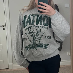 Grå crewneck med tryck - Supersnygg grå crewneck med grönt tryck från Bershka. I storlek S och i bra skick. 