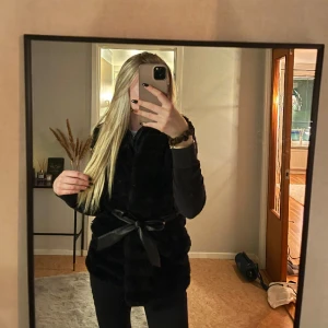 Fluffväst 🖤 - En svart fluffig väst ifrån amisu. Fakeläder-skärp i midjan. Storlek: M, passar även S