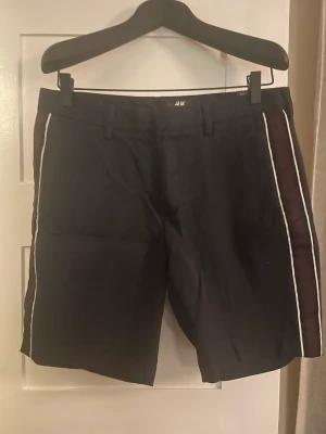 Marinblåa shorts - Marinblåa shorts med rand (gros grain) i vinrött. Helt nya med prislapp kvar 