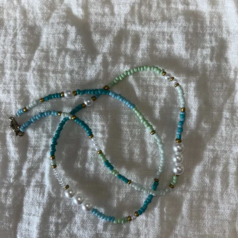 Halsband med olika nyanser av grön med detaljer av guld och pärlor. Går att få ett matchande armband⚡️(även annan färg om det önskas)❤️. Accessoarer.