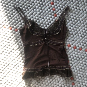Brun glittertopp  - Säljer denna fina bruna, glittriga mesh-linne! Super fin till sommaren lite i Y2K stil🤙