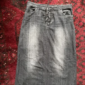 Svart jeanskjol - Lång svart jeanskjol med snörning där uppe. Snörena är lite slitna men dem går oxå att byta! Står ingen strl men skulle säga mellan S-M. Assnygga men behöver rensa garderoben! Pris kan diskuteras 