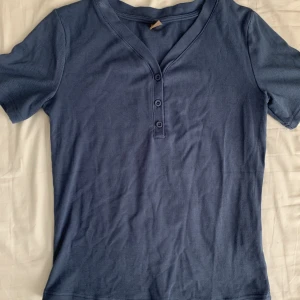 Blå topp - Blå topp med knappar. Jätteskönt material!