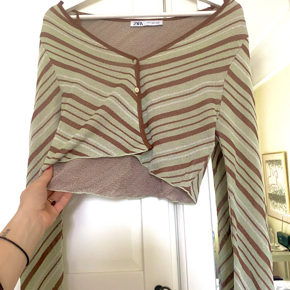 Oanvänd topp från zara med vida armar, grön & brun i tunnt tyg. Perfekt över en klänning eller till en kjol . Puserot.