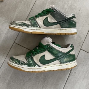 Nike Dunk low - Nike dunk low köpta här på plick, original vita men tror de målades med grön skofärg, riktigt snygga och bristningarna i färgen ger enligt mig skon en snyggare touch