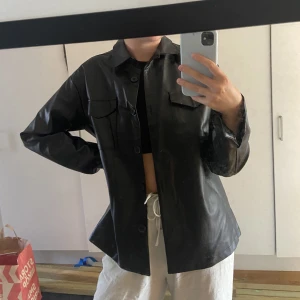 Skinnskjorta/jacka - En tunnare shorta/jacka i skinnimitation. Köpt får några år sedan men bara använd 2-3 gånger. Väldigt bra skick. 