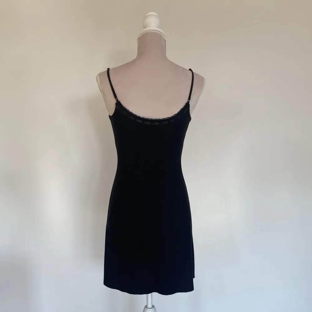 Kort svart klänning från Urban Outfitters, i ny skick, med spets och rosett detaljer . Klänningar.
