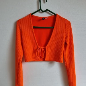Orange croptop  - Säljer en orange croptop med knytning där framme i storlek S, använd sparsam! Kan mötas upp eller posta