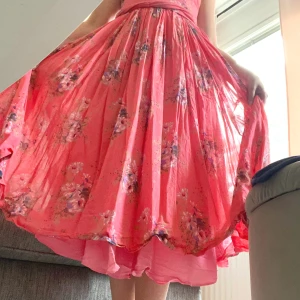 Rosa klänning  - En rosa klänning med fylliga kjolar som passar utmärkt till midsommar. Dragkedja och snörning i ryggen för perfekt passform   Slutar på halva vaden   Superfint skick 