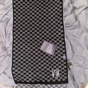  Louis Vuitton halsduk -  Jag har bestämt mig för att sälja min halsduk för jag har två styckna och ingen användning utav den ni ser på bilden.  Anledning till att jag säljer den billigare Är för att den är använd samt behöver bli av med den snabbt. 