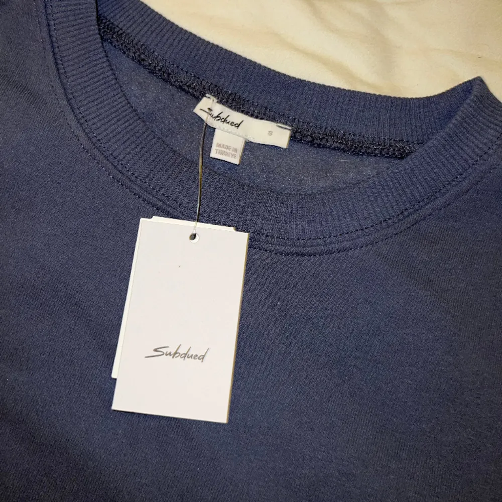 En blågrå sweatshirt från märket Subdued. Lite oversized passform. Aldrig använd och prislappen kvar. Nypris ca 340kr. Hoodies.