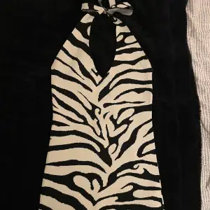 Halterneck klänning i zebra mönster. Endast använd 2-3 gånger så den är så gott som ny! Köpt på Gina Tricot🖤🤍