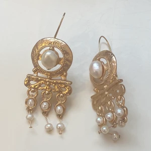 Örhängen  - Stora guldfärgade örhängen med pärlor  Okänt material 