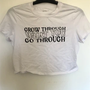 Vit croppad T shirt i stl L - Vit croppad T shirt i stl L. Använd ett fåtal gånger. På tröjan står det ”Grow through what you go through”. Tröjan är från shein.