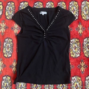 Svart topp - Fin svart topp med vita pärlor på från märket Gianini