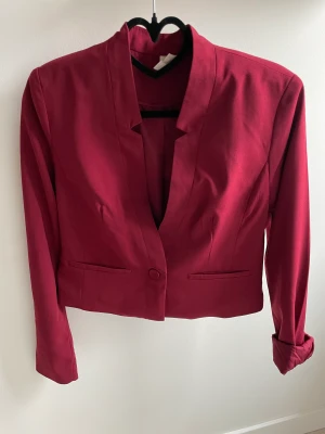 Midjemått kavaj. - Färg: vinröd Längd: midjelång Str: S  Märke: från primark