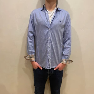 Burberry Skjorta  - Hej! Säljer nu min skjorta från märket Burberry, storlek M fint skick. Varan är givetvis äkta. Modellen är 180cm och väger 70kg Tveka inte på att höra av dig om du har frågor eller funderingar kring varan!