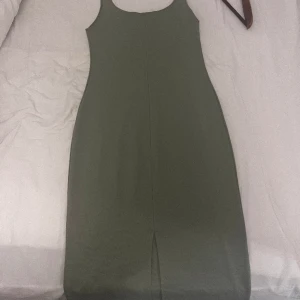 Grön klänning - En grön tajt klänning från Zara. Använd 2-4 gånger. Sitter sjukt fint på och ger en fin figur. Även en slits där bak. Köpt för 350 kr