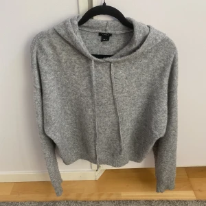 Stickad hoodie - Trendig grå slutsåld stickad hoodie från Lindex! Säljer då den ej kommer till användning. Sparsamt använt och därför i bra skick!