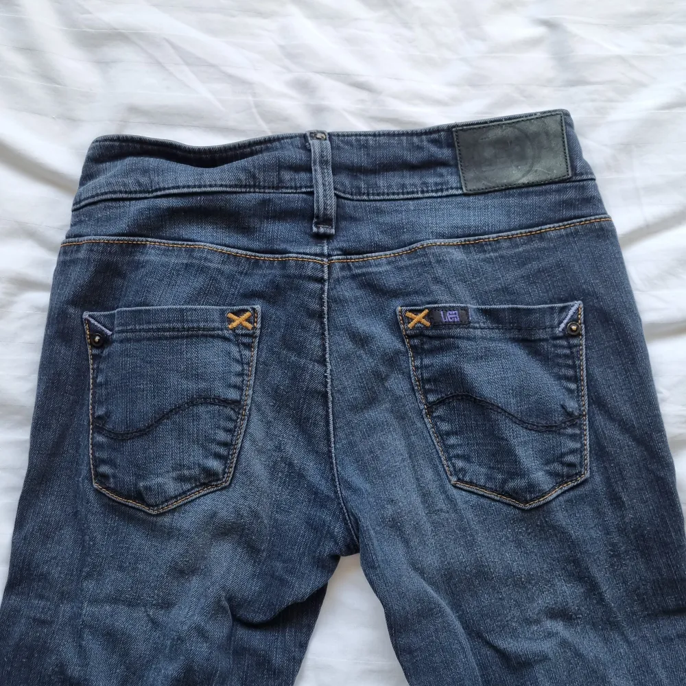 Lågmidjade jeans från Lee i bra skick. Rak, med något utsvängt i modellen. Färgen är lite grå/blå. Strl 27/31 Midja: 35 cm Innerbenslängd: 77 cm Ytter: 96 cm. Jeans & Byxor.