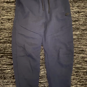 Nike tech Fleece Byxor Size M - Storlek M Nike tech fleece Navy Blue 🇬🇧  Köpt på JdSport förra året men ej gått till användning. Köparen står för frakten. Buda på!🙂 (Obs inga meet ups)