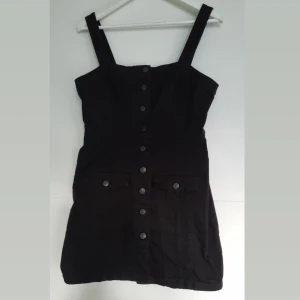 Svart jeansklänning - Snygg klänning i jeanstyg, endast använd en nyår för något år sedan.  Sitter snyggt och bekvämt! 