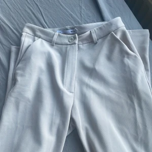 Kostymbyxa - Byxorna är i nyskick och endast använda 2 gånger. Färgen är en fin ljusgrå färg nästintill vitt . Byxorna är väldigt elastiska och passar någon som i vanliga fall bär S möjligtvis även M.