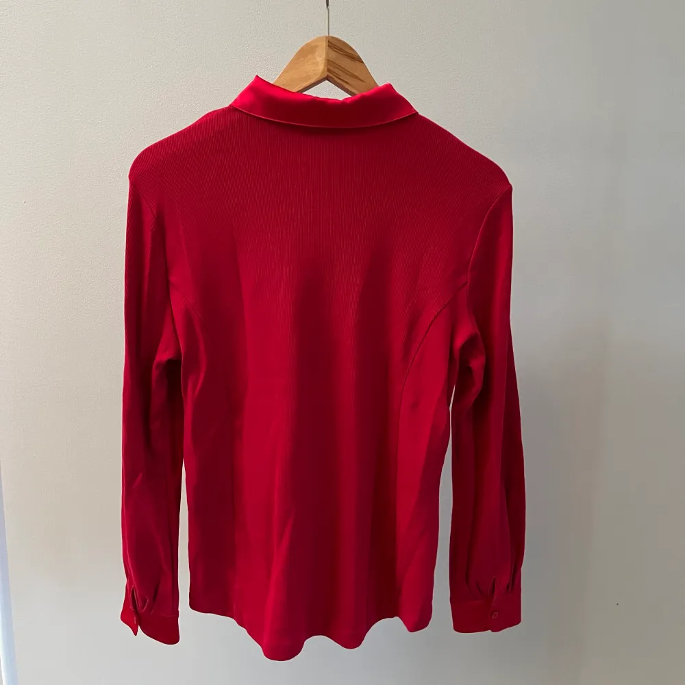 En rosa/röd skjorta från Kettlewell. I 95% bomull och 5% elastan. Har själv köpt den begagnat men har bara använt den två gånger så i fint begagnat skick.. Skjortor.